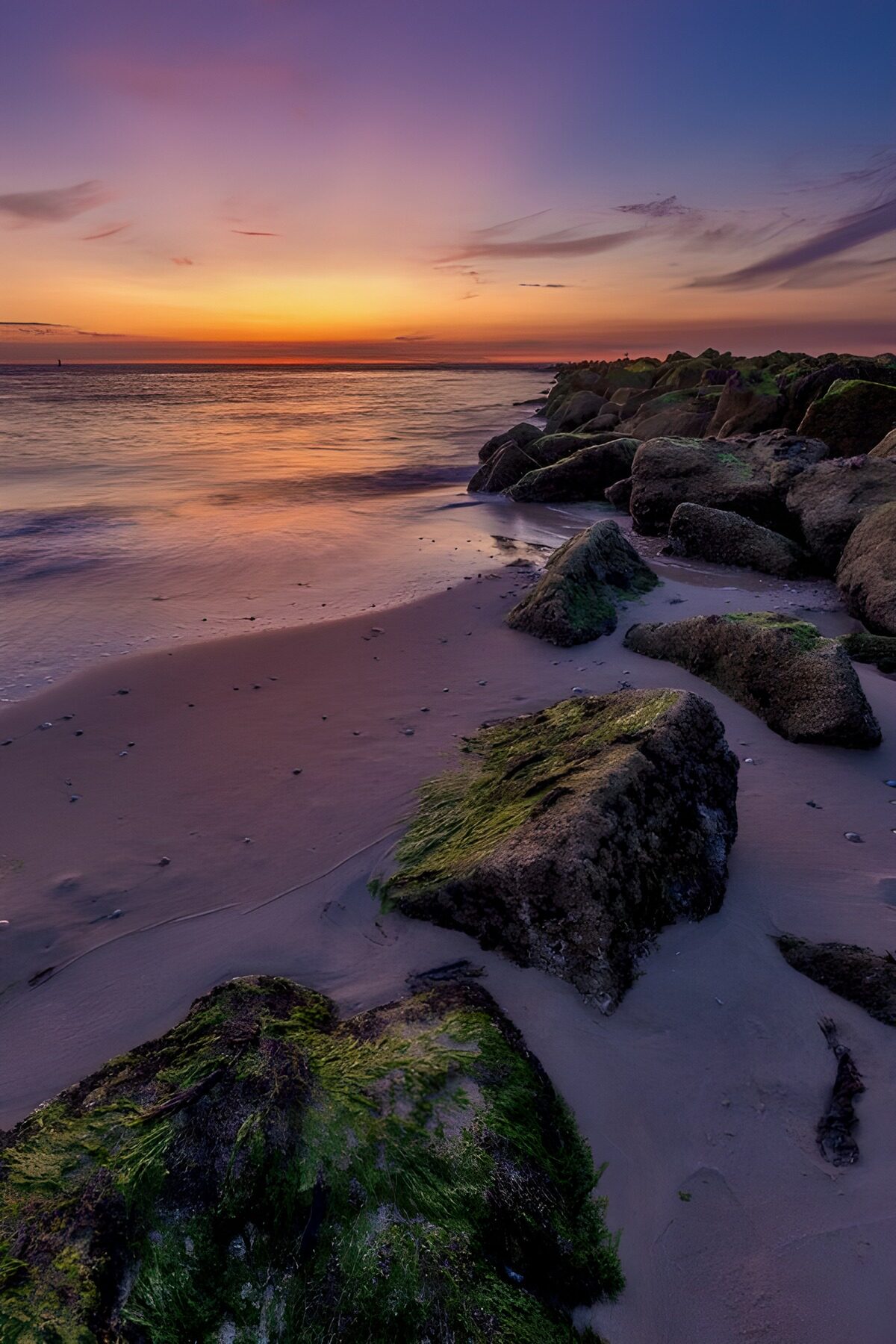 TPDE44257: Sonnenuntergang am Strand mit Felsen