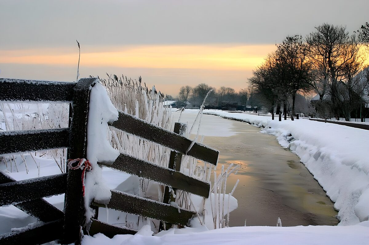 zugefrorener Graben in einer verschneiten Winterlandschaft