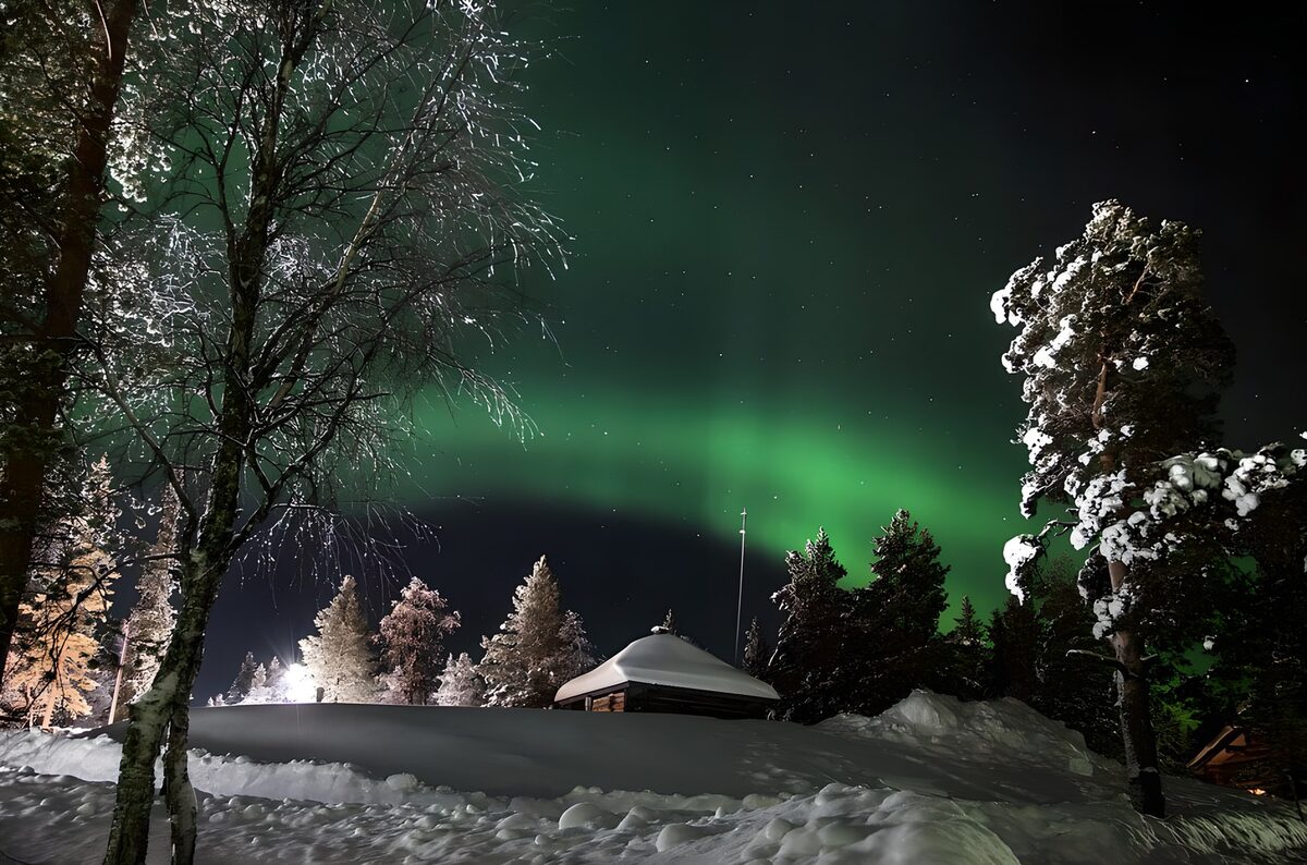 märchenhafter Blick auf "Hytter" im grünen Nebel vom Polarlicht