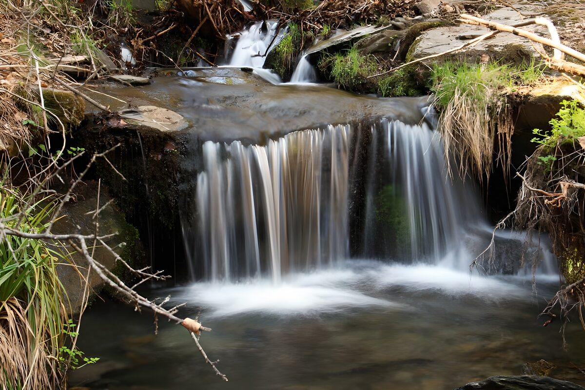 TPDE88311: Felsen, Steine und Pflanzen an einem kleinen Wasserfall  