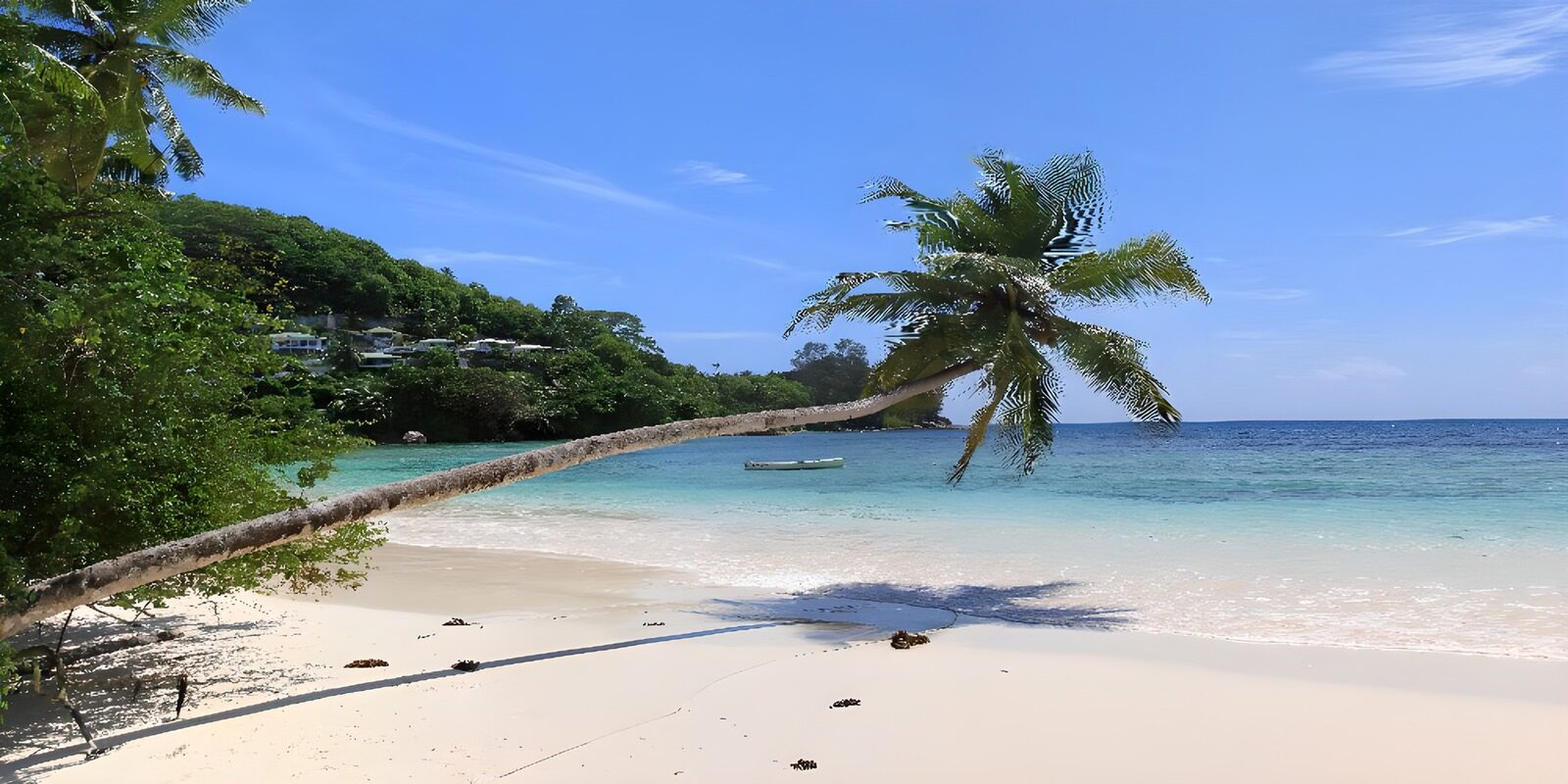 TPDE87565: eine Bucht mit Strand und Palmen, in den Hügeln die Häuser der Einwohner dieser Region