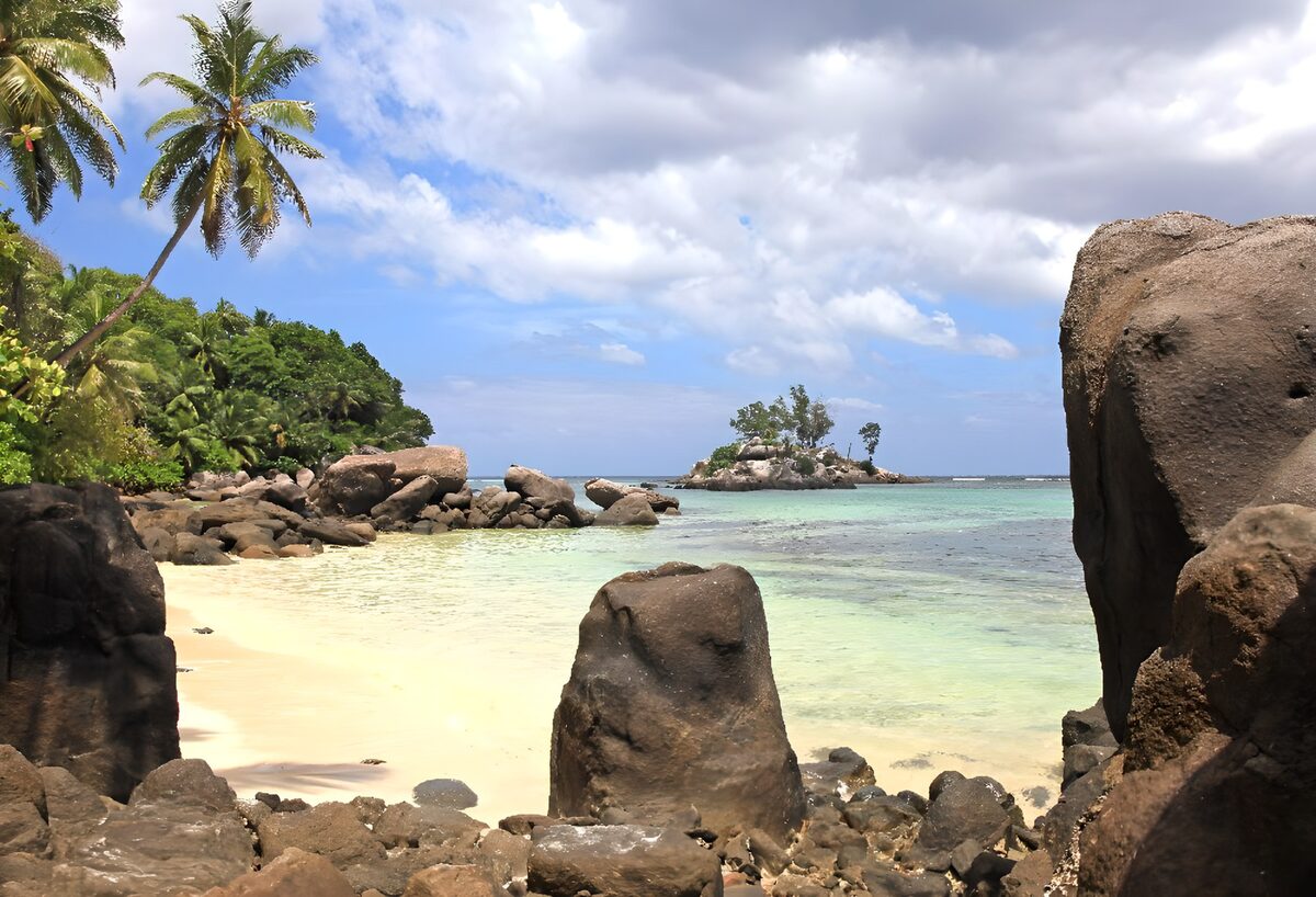 TPDE97669:  Felsen am Strand, in der Ferne eine Insel