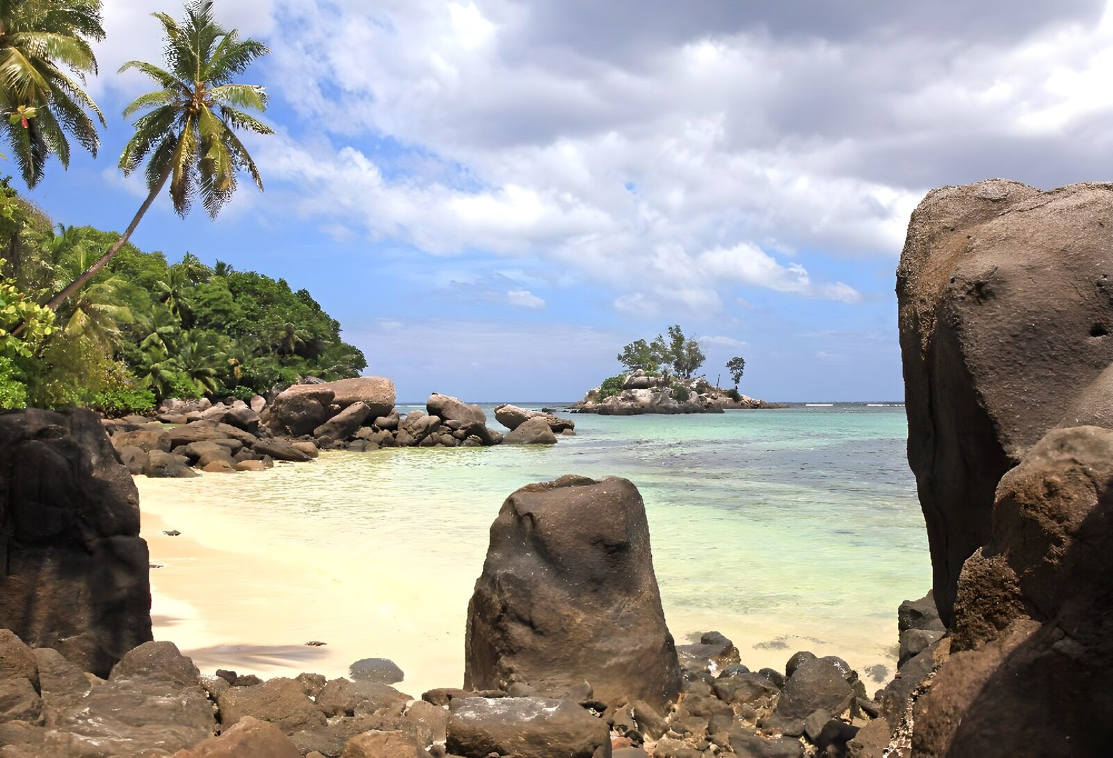 TPDE97669:  Felsen am Strand, in der Ferne eine Insel