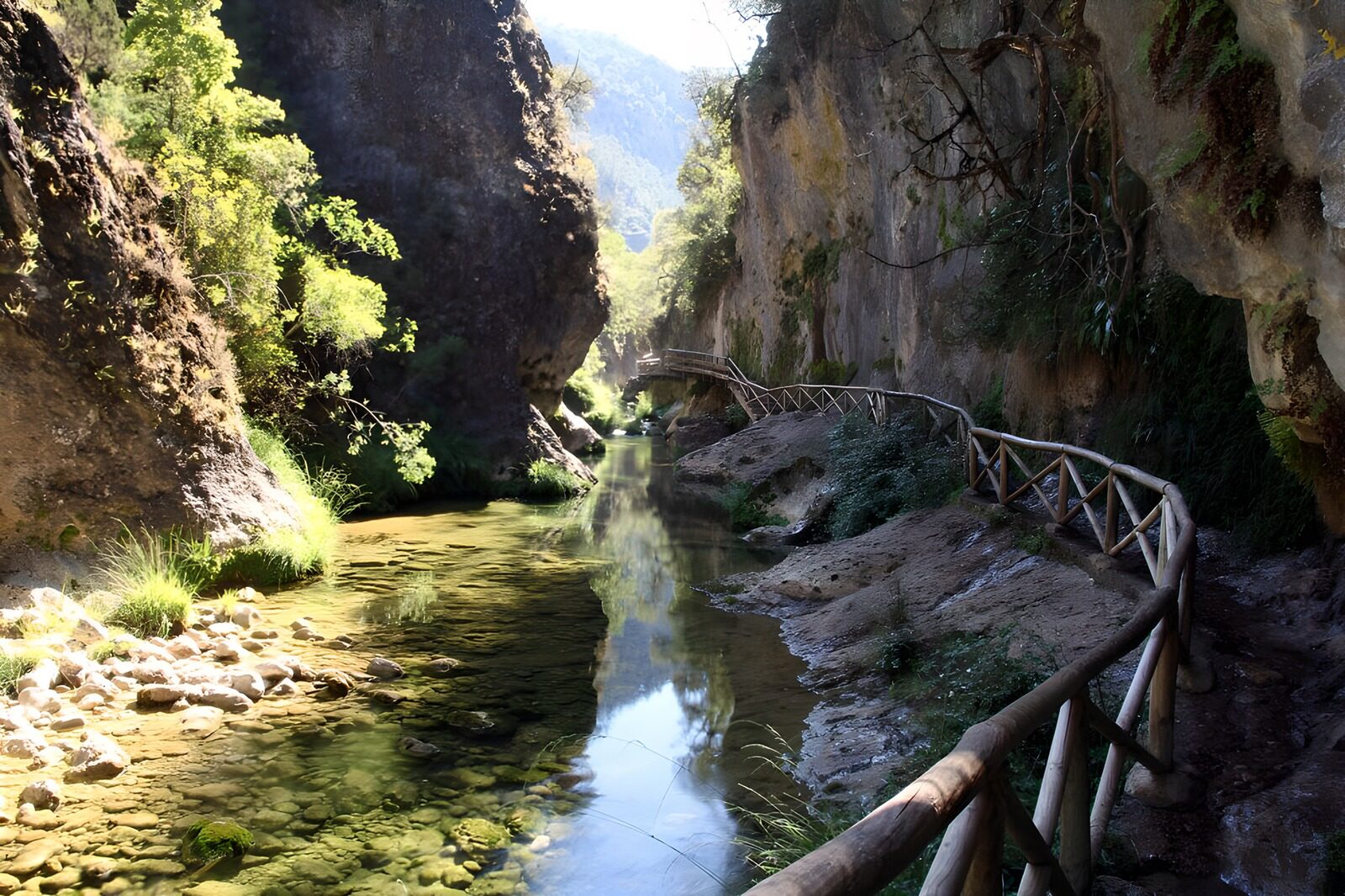 TPDE64015: Hölzener Steg  an massiven Felsblöcken und einem Wasserfall vorbei