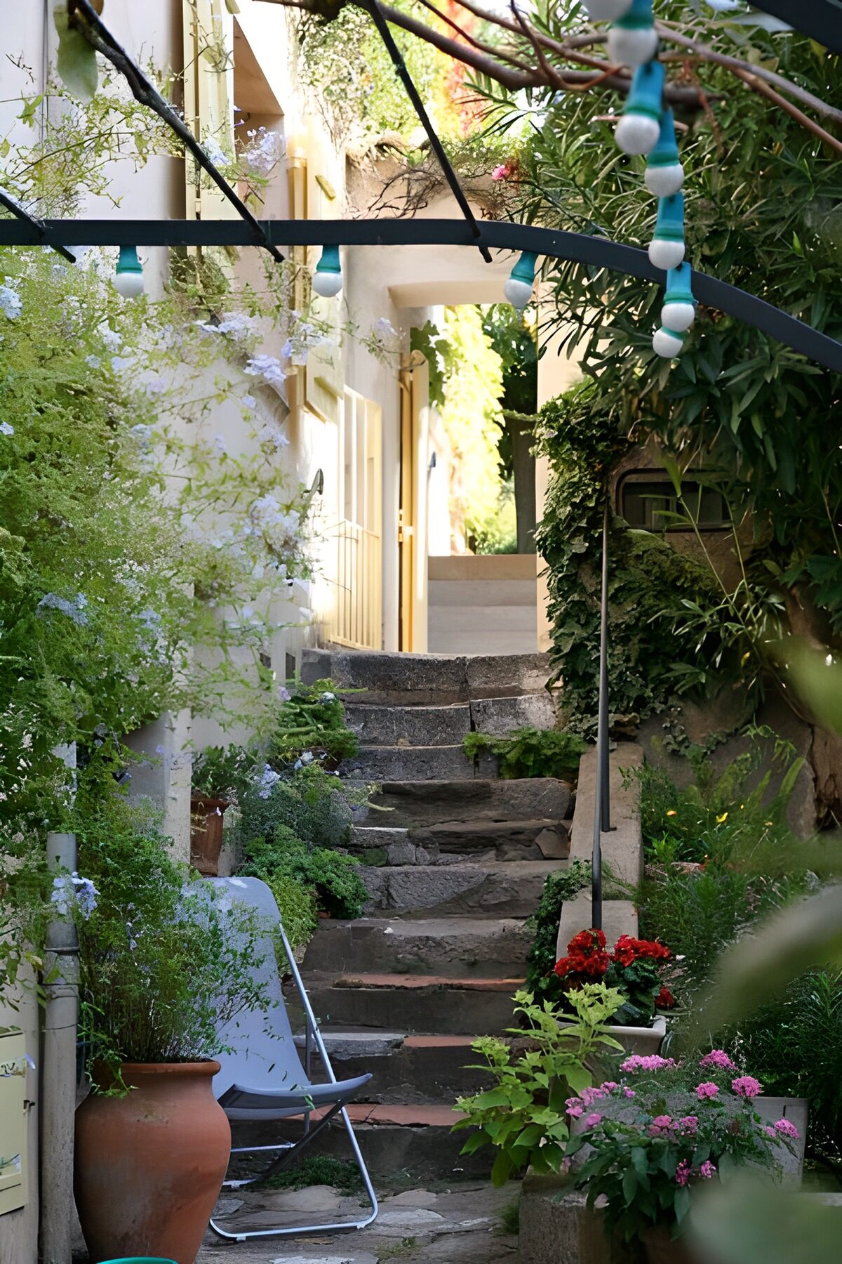 TPDE81020: Treppe zum Eingang eines Hauses mit Lichtern und Stuhl