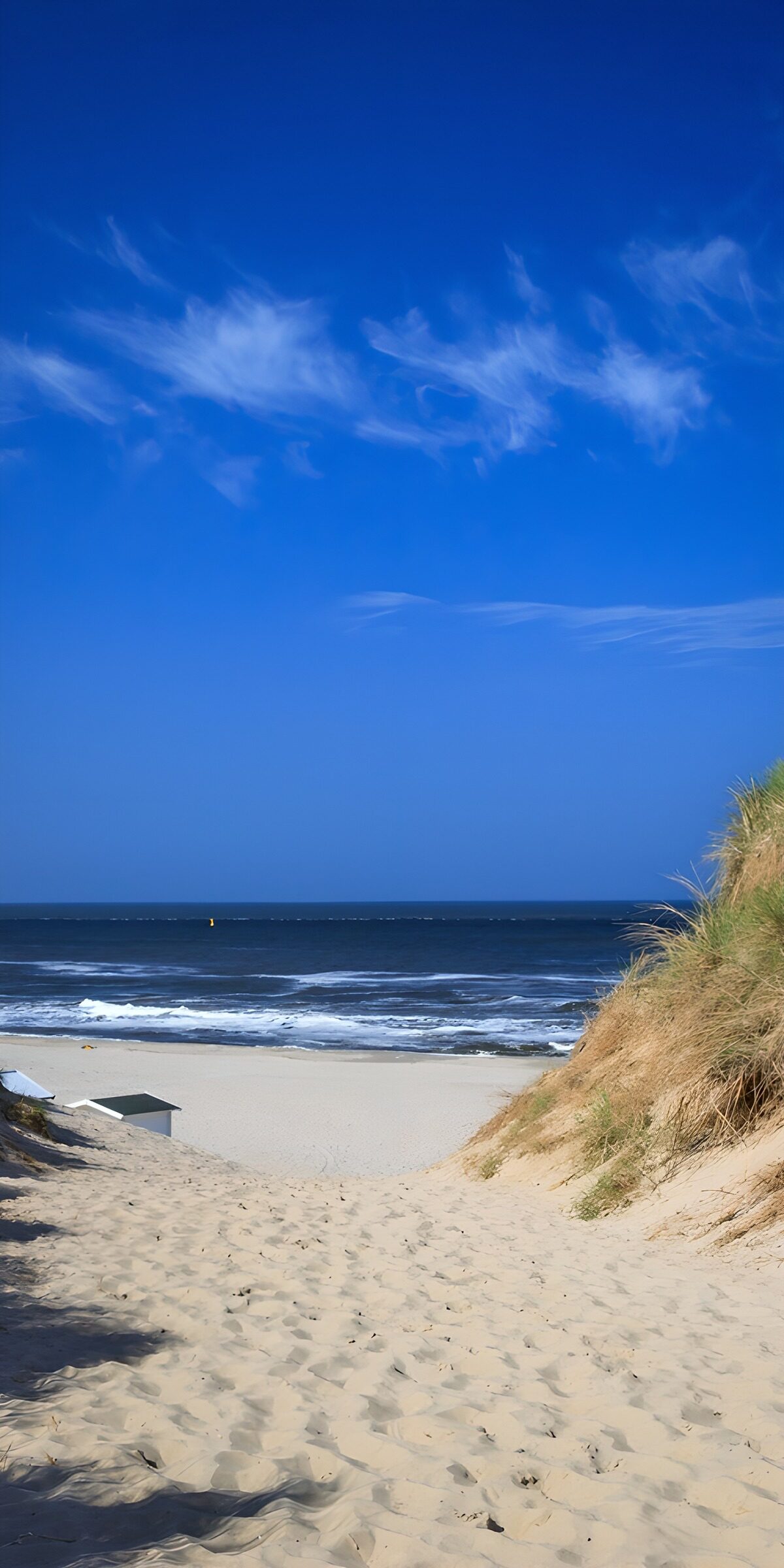 Sandweg zum Strand mit blauem Himmel