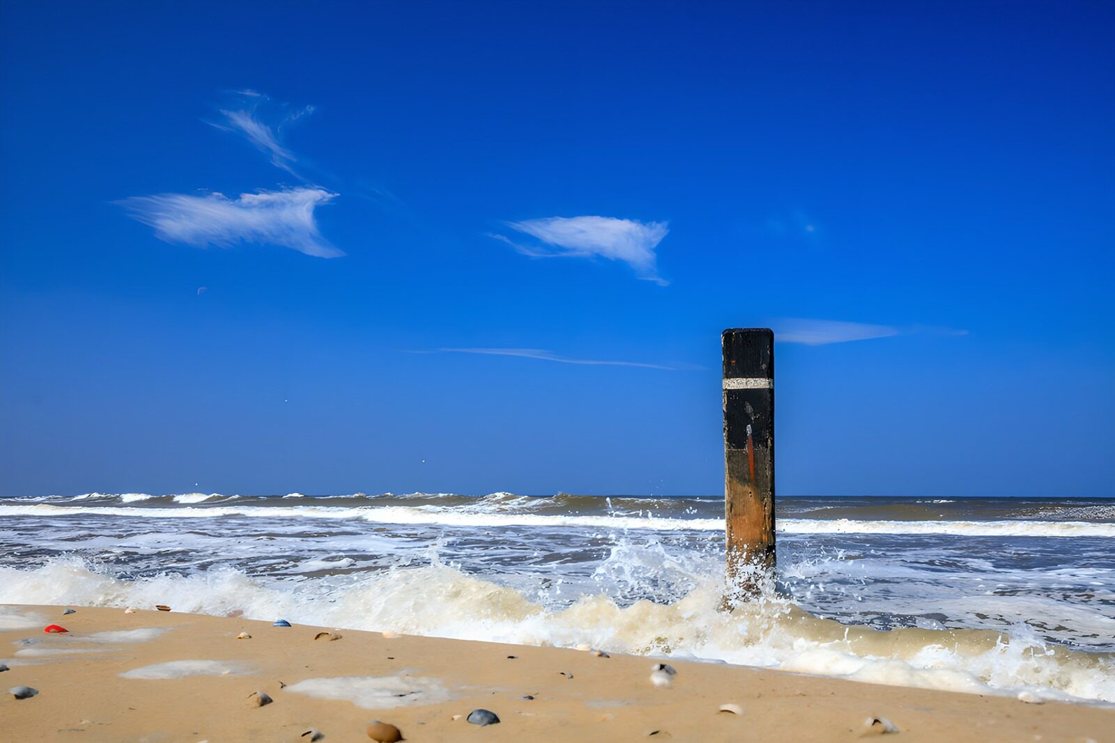 TPDE52842: Wellen am Strand mit Holzpfosten