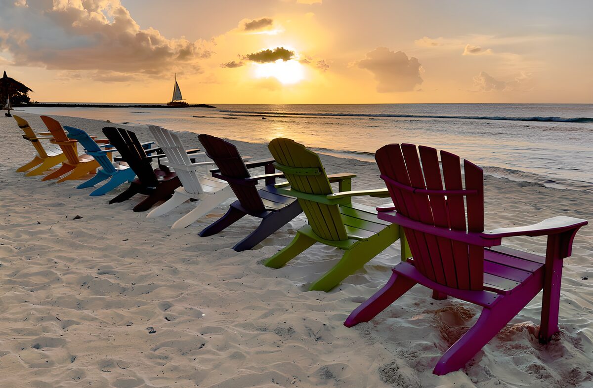 TPDE81217: Bunte Liegestühle am Strand gegen Sonnenuntergang