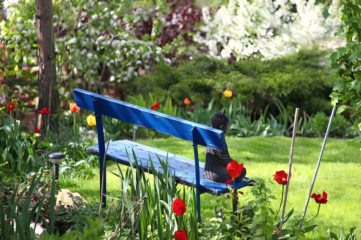 ein kleiner Junge auf einer blauen Bank in einem Garten