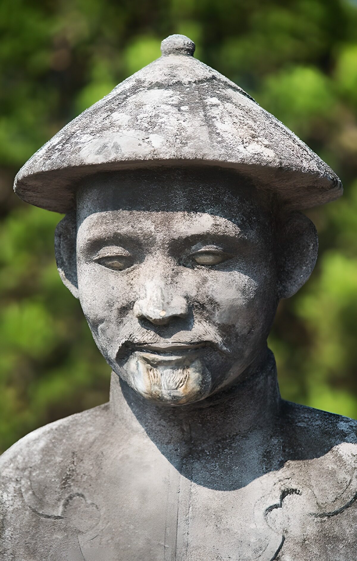 Statue eines Chinesen mit  tradionellem Hut