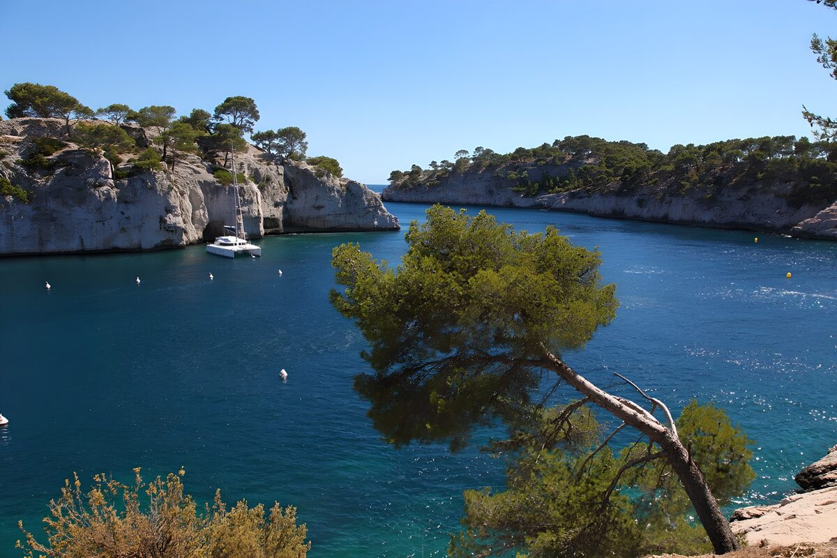 Aussicht auf eine Bucht an der Côte d'Azur, wo ein Katamaran vor Anker liegt