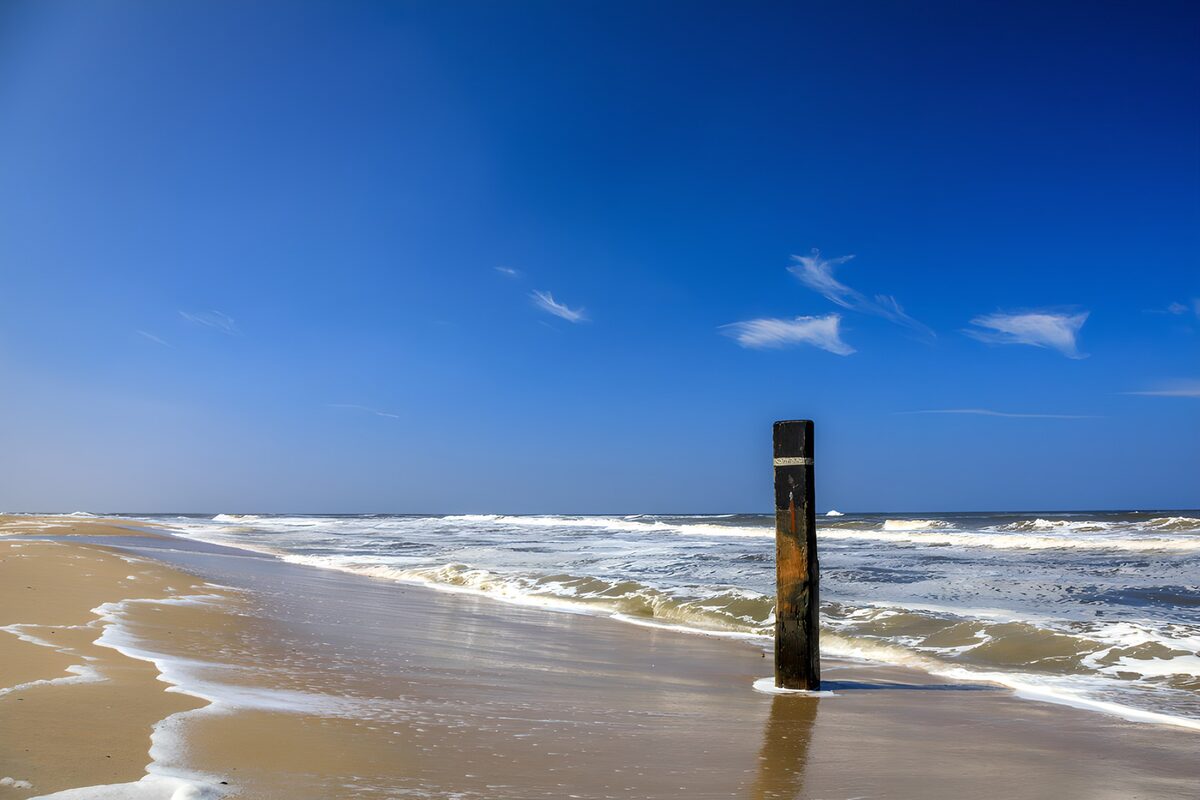 TPDE81999: Strand mit Pfahl und klarem Himmel