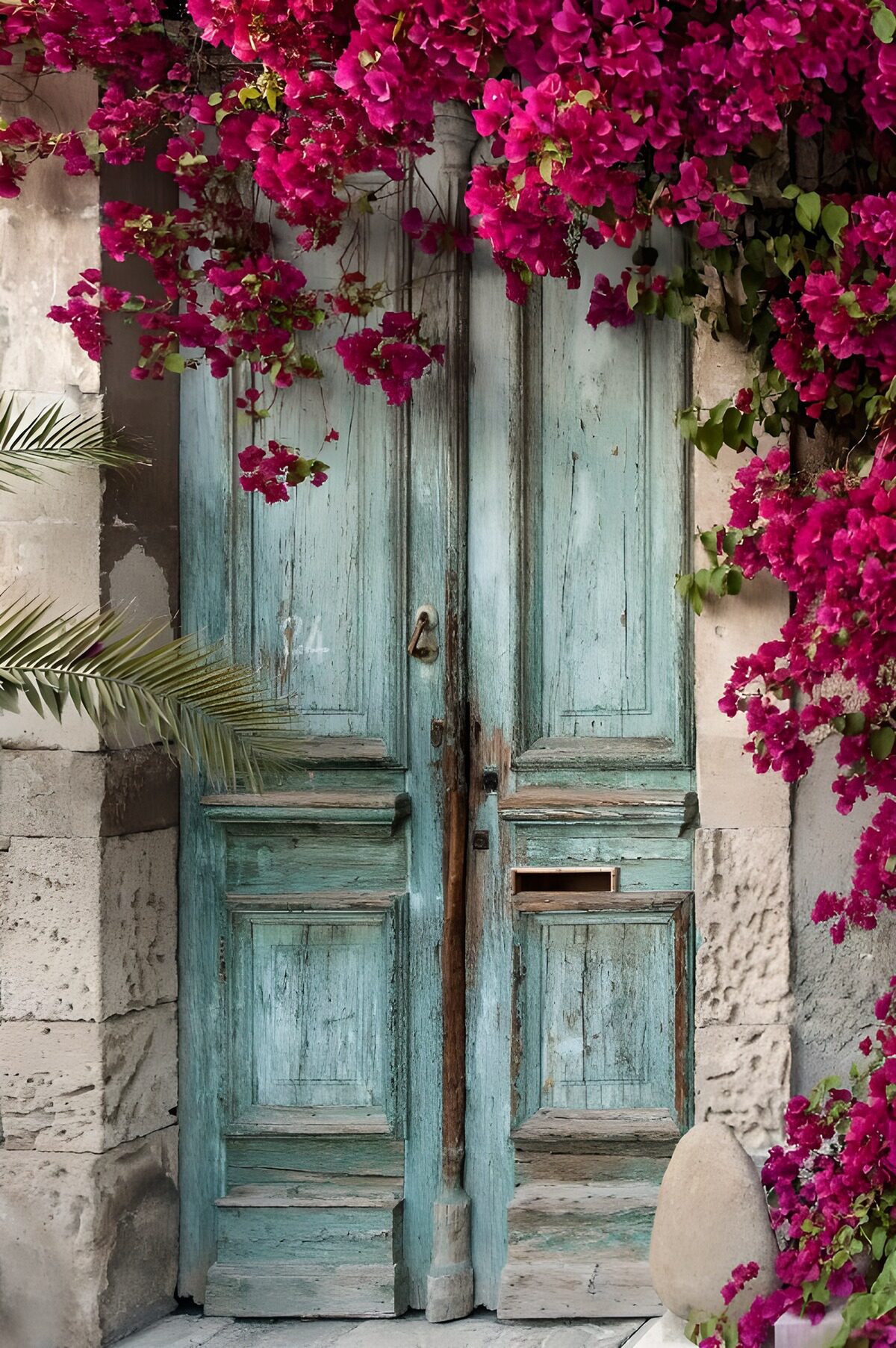 Altes, blaues Tor und roter Bougainvillea